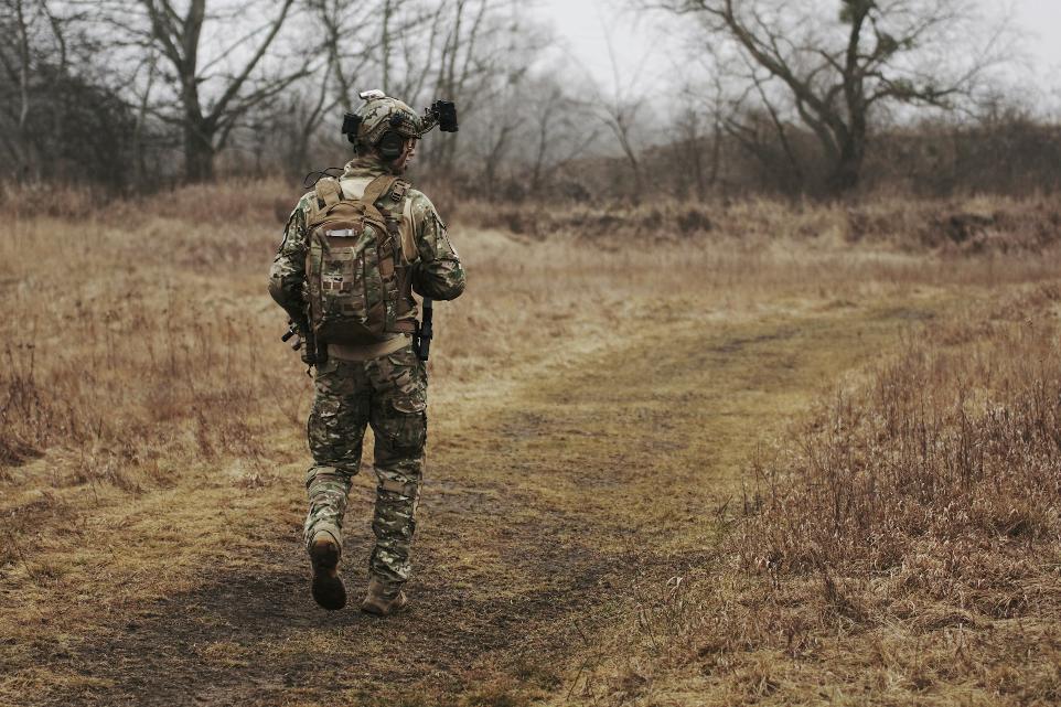 man walking on brown grass field